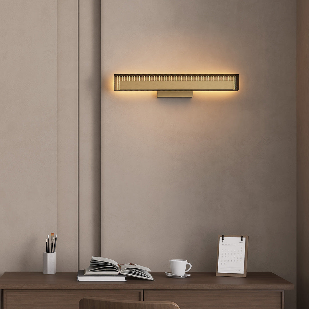 Warm brass wall picture lights mounted above desk, adding soft ambient glow.