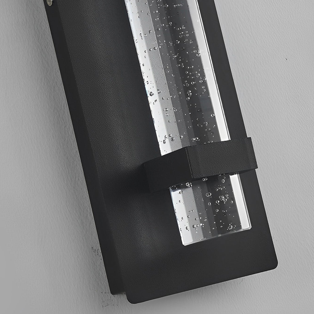 Close up of bubble wall sconce with textured glass tube and black metal frame showing refined lighting details.
