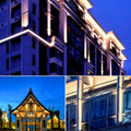 Commercial building facade illuminated by decorative wall wash lighting.