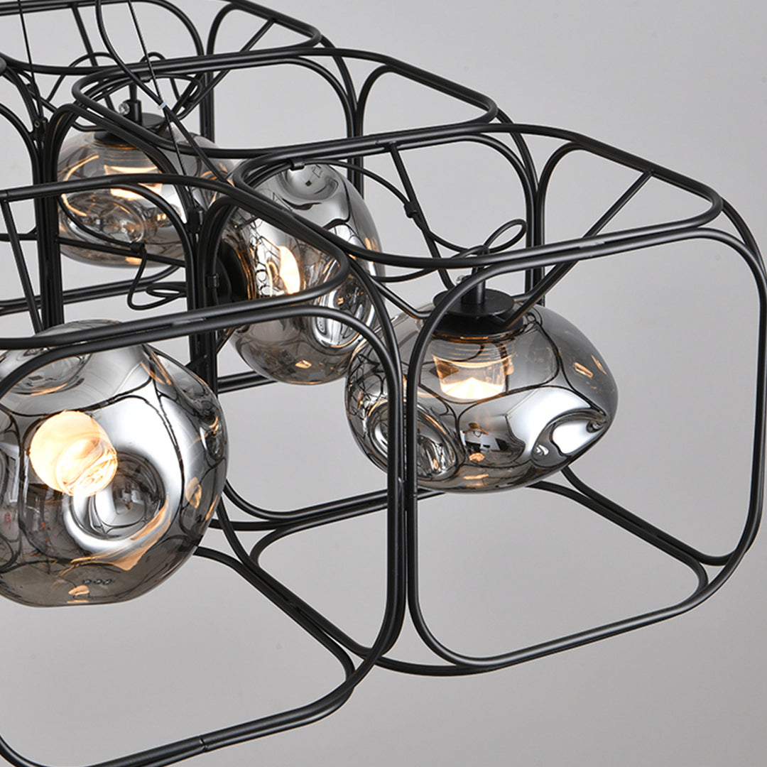 Multiple caged pendant light units grouped together, forming a sculptural lighting feature with warm illumination.