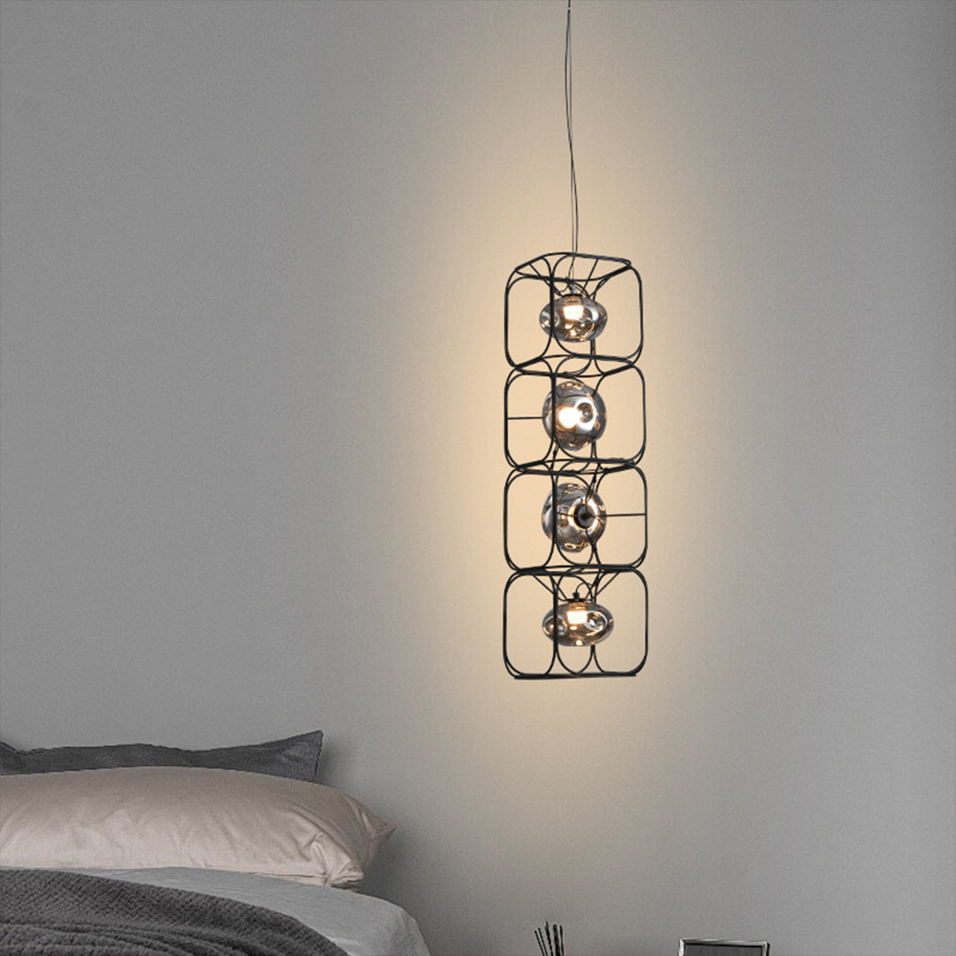 Multi light caged pendant light with stacked metal frames, providing warm illumination for a minimalist bedroom setting.