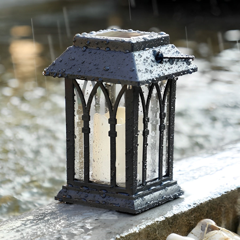 Candlestick lantern illuminating garden pathway with lush greenery.