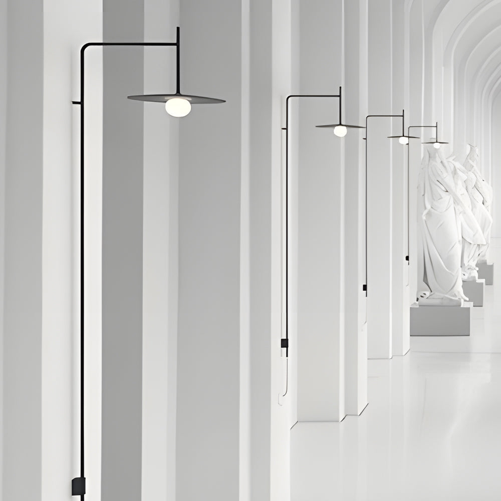 Linear cantilever wall lamp installed along a white corridor, showcasing elegant proportions and architectural lighting design.