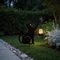 Cat silhouette light illuminating a garden pathway with warm, whimsical glow.
