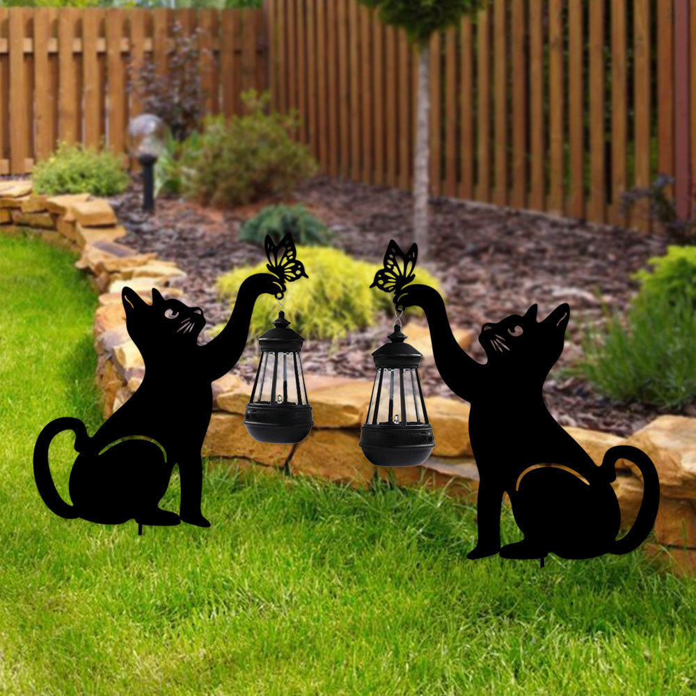Cat silhouette light providing warm light beside a wooden fence.