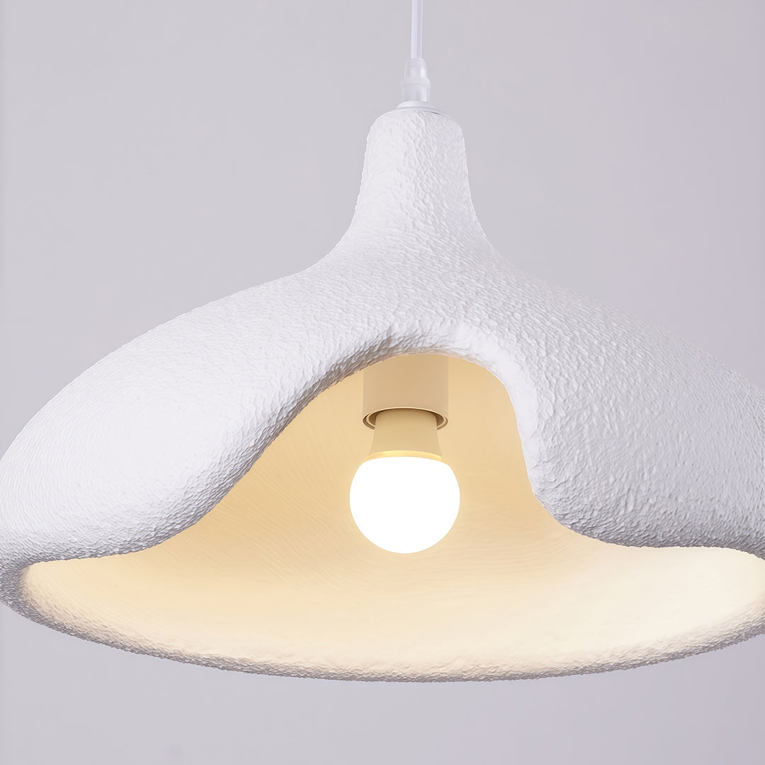 Close-up of cement pendant light with smooth curved design and soft warm light glow.