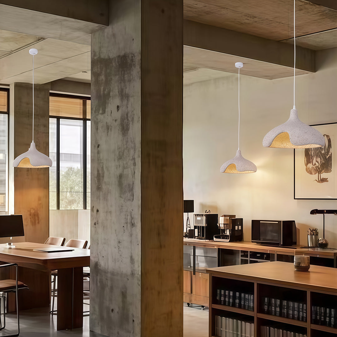 Cement pendant light with organic shapes hanging in contemporary workspace interior.