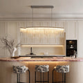Chain tassel chandelier with a gold finish, providing elegant illumination above a kitchen island.