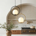 Chic Round Frame Pendant light pair with opal globes in a modern kitchen with an arched wall.
