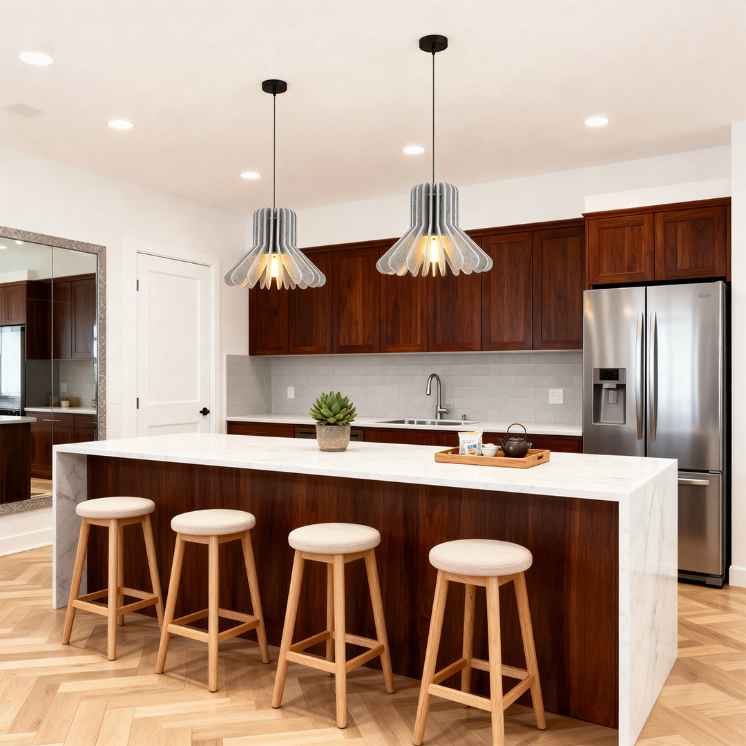 Sleek chrome tiny pendant lights hanging over a long white kitchen island with bar stools