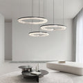 Circle pendant light with a metallic frame, illuminating a cozy seating area in a stylish interior.