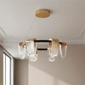 Striking circular chandelier modern design featuring a black and gold ring frame with draped textured clear glass pendants.