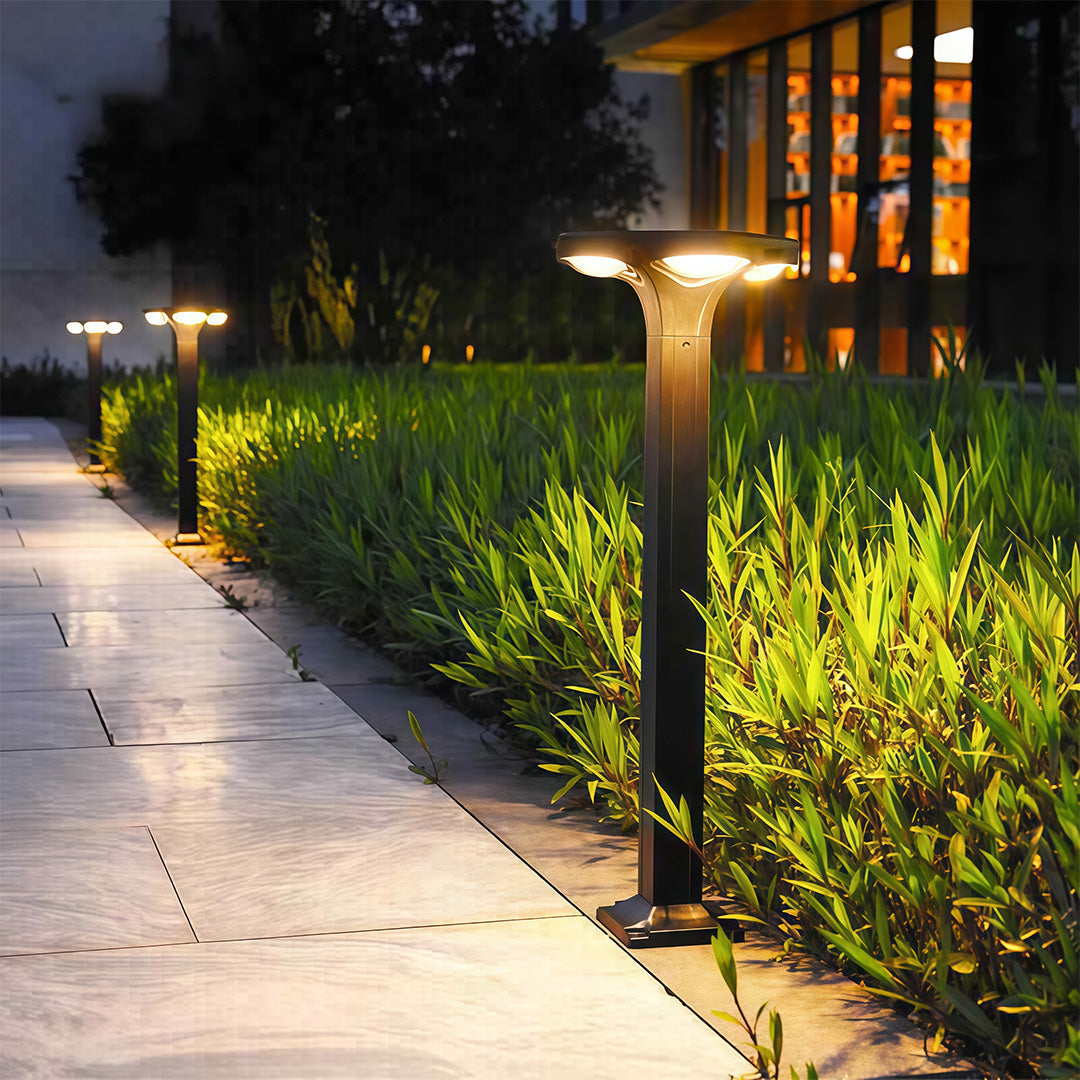 Classic black wall-mounted outdoor light next to a doorway, casting a warm glow.
