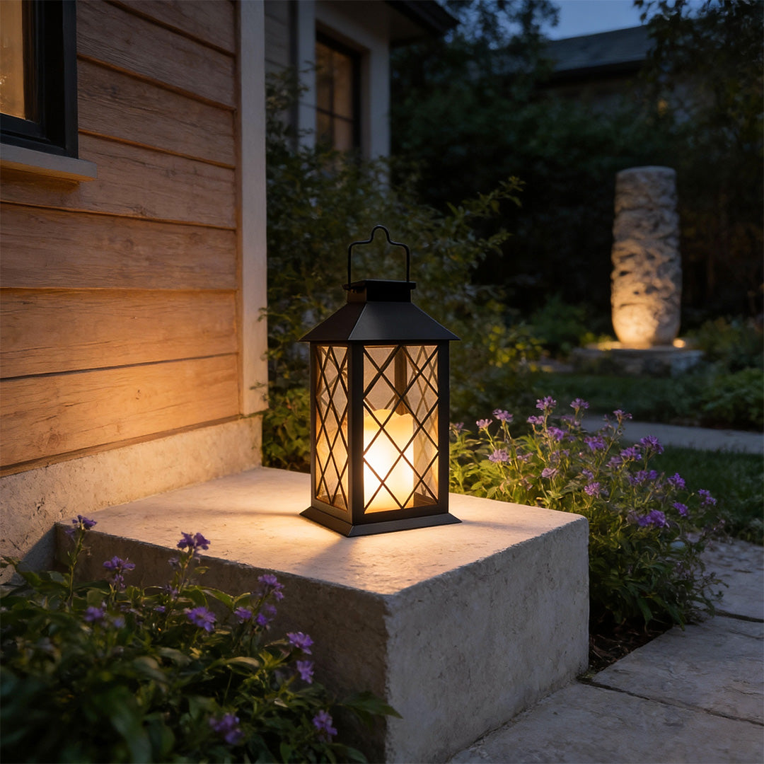 Candlestick lantern with classic black design illuminating garden pathway at night.