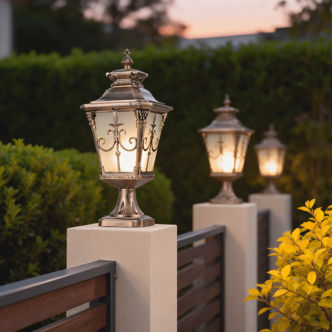 Classic cast aluminum post light featuring ornate bronze finish and clear glass panels for outdoor ambiance.