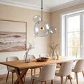 Clear bubble chandelier installed above modern dining table with gold accents.