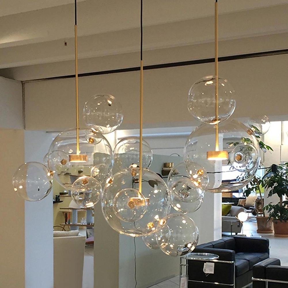 Cluster clear bubble chandelier with warm lighting in open-plan interior.