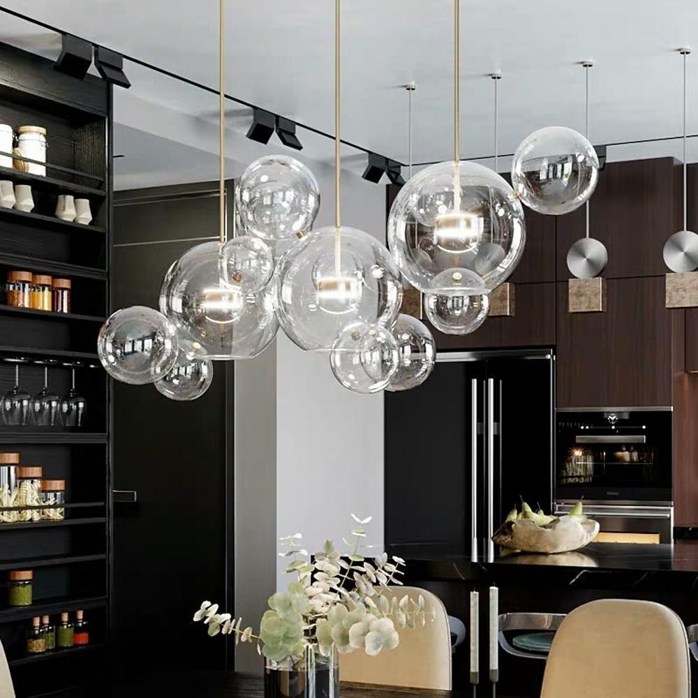 Clear bubble pendant chandelier arranged in linear ceiling installation.