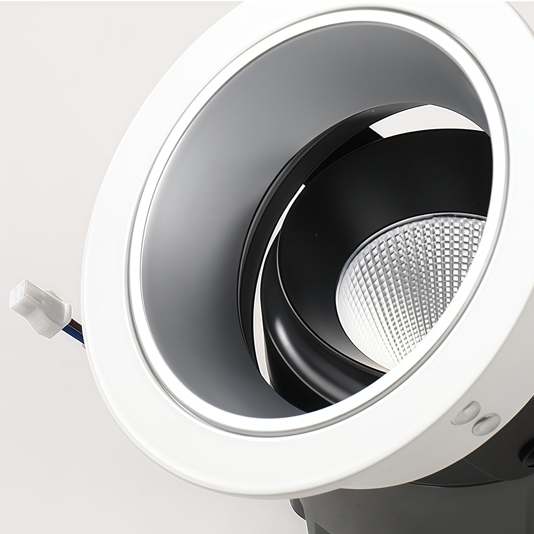 Close-up of flush mount spotlights with glass shade chandelier inspired white trim and angled black reflector detail.