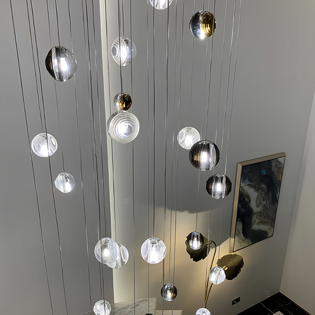 Close-up of metal pendant lights with smoked glass spheres, showcasing their sleek design and reflective surfaces.
