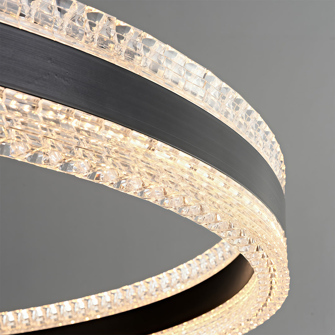 Close up of a modern circular chandelier showcasing crystal details and a gold frame.