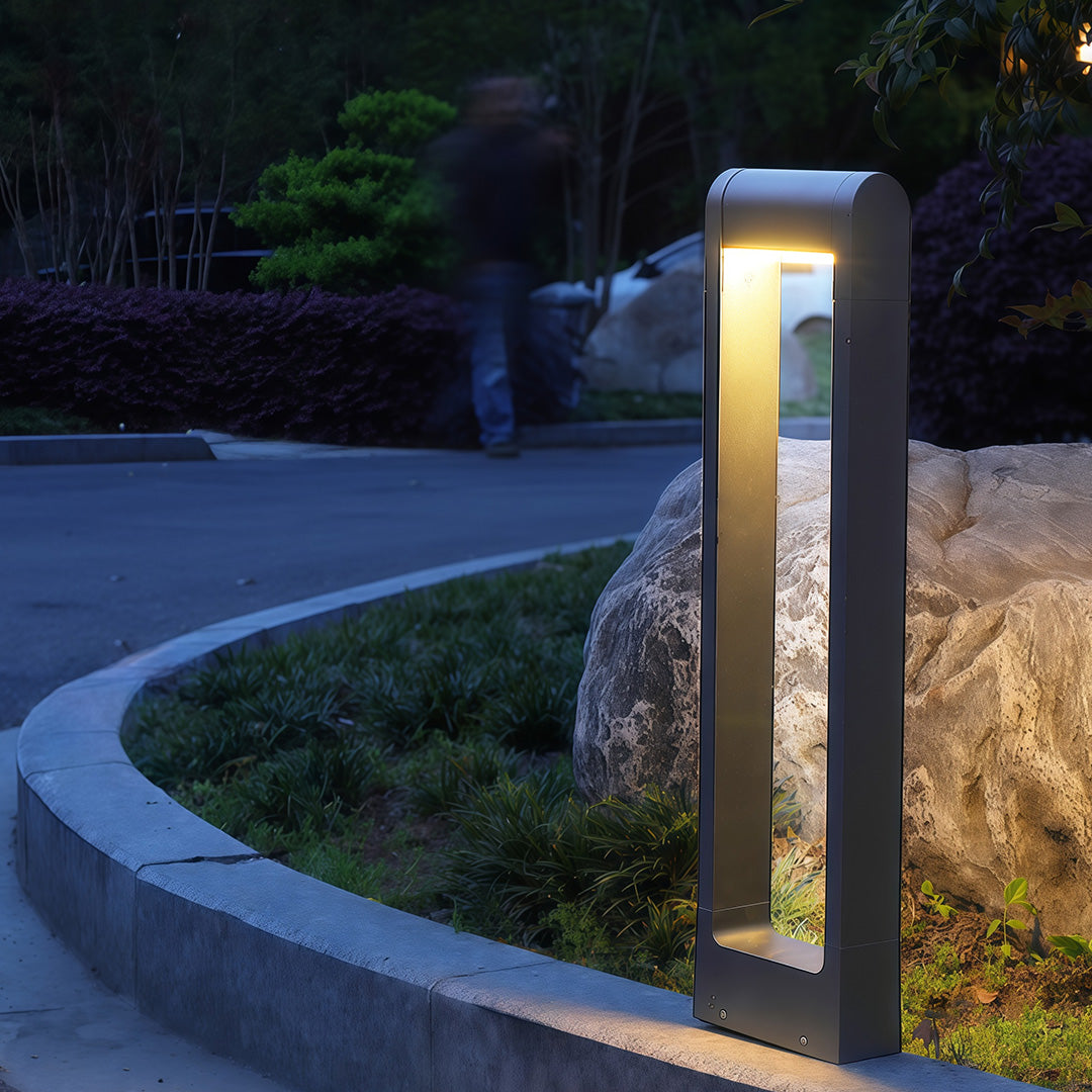 Close-up of a pathway bollard light, highlighting the black finish and light source.