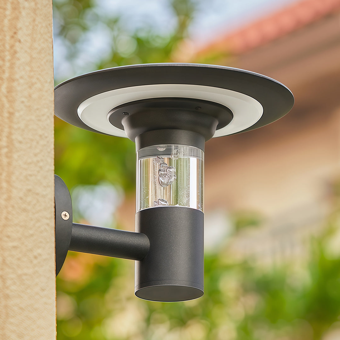 Close-up of the solar outdoor wall lighting fixture showing the bubble glass and black 'halo' design on a pillar.