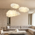 Modern cloud-like pendant light installed in a minimalist living room with soft ambient lighting.