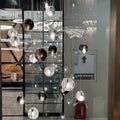 Cluster of metal pendant lights with transparent and smoked glass spheres hanging in a modern retail display.