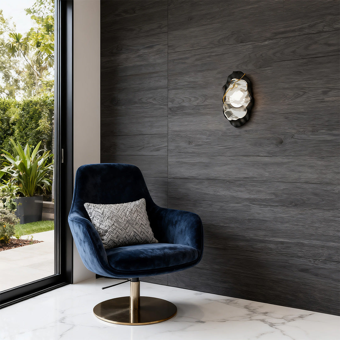 Contemporary black wall light providing ambient lighting on grey textured wall near blue chair