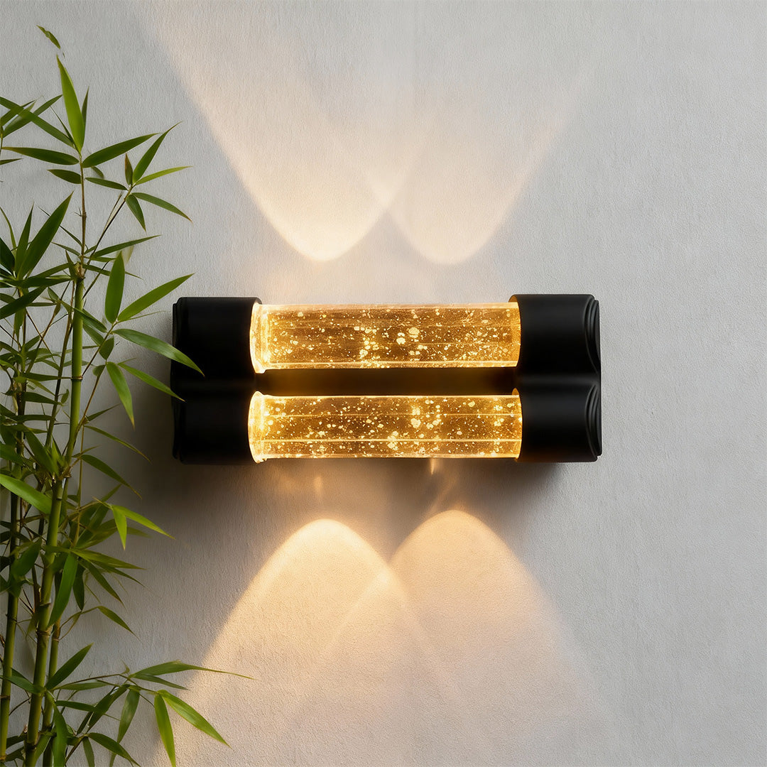 Contemporary crystal wall sconce light fixture featuring glass shade chandelier styling creating warm up-down illumination on interior wall.