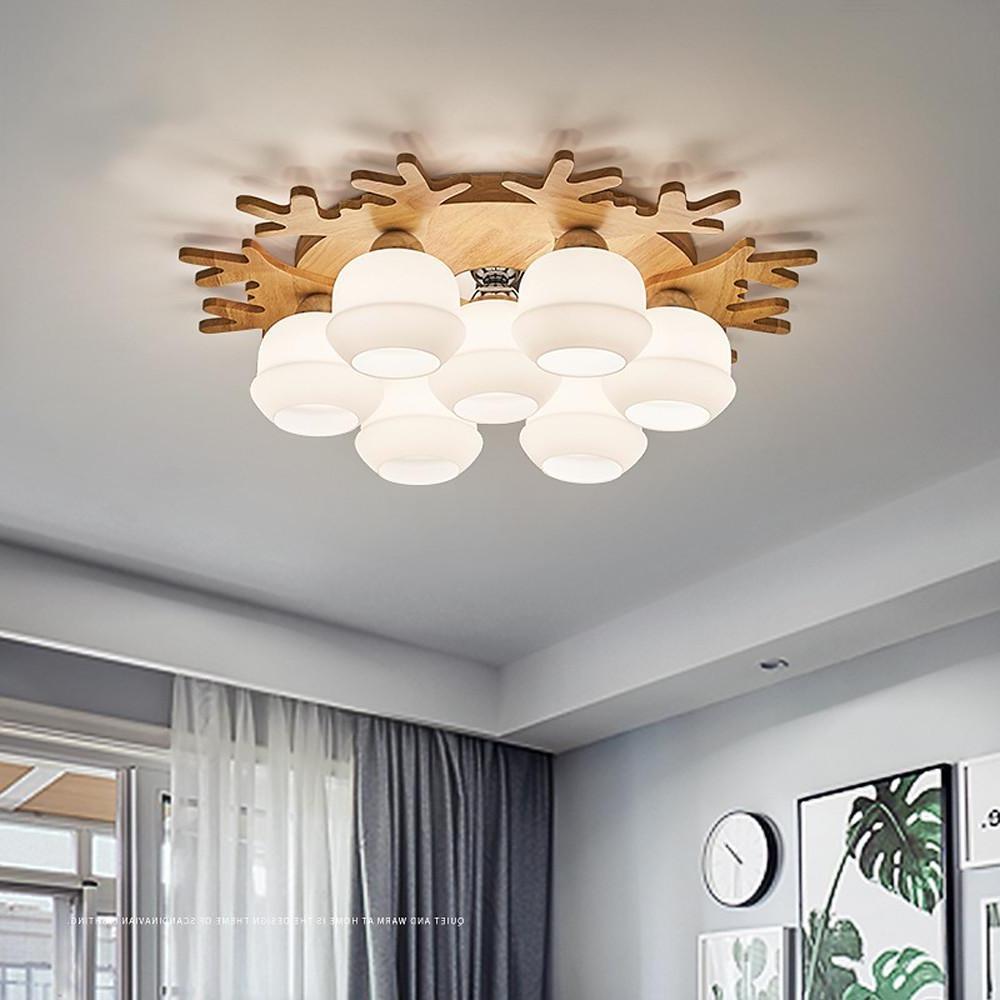 Contemporary flush mount globe ceiling lamp with wood base and frosted globes in a neutral interior setting.
