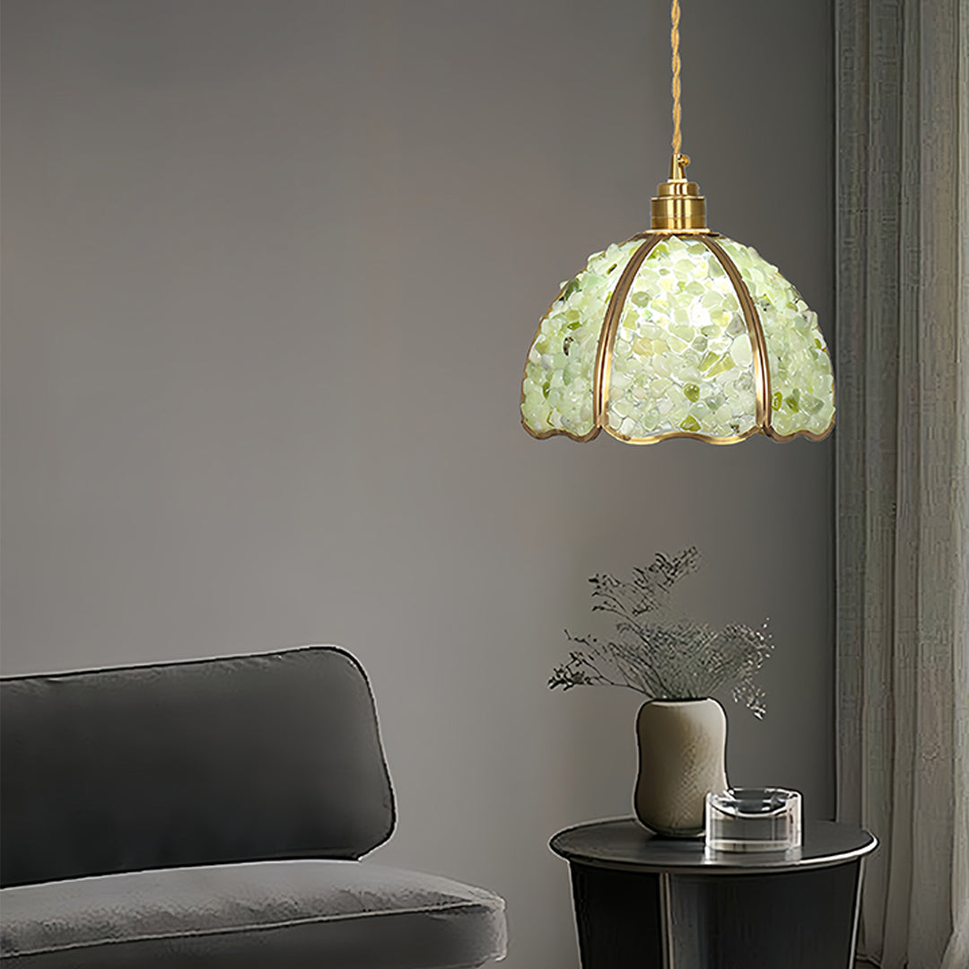 Green crystal pendant light hanging in contemporary living room with modern furniture