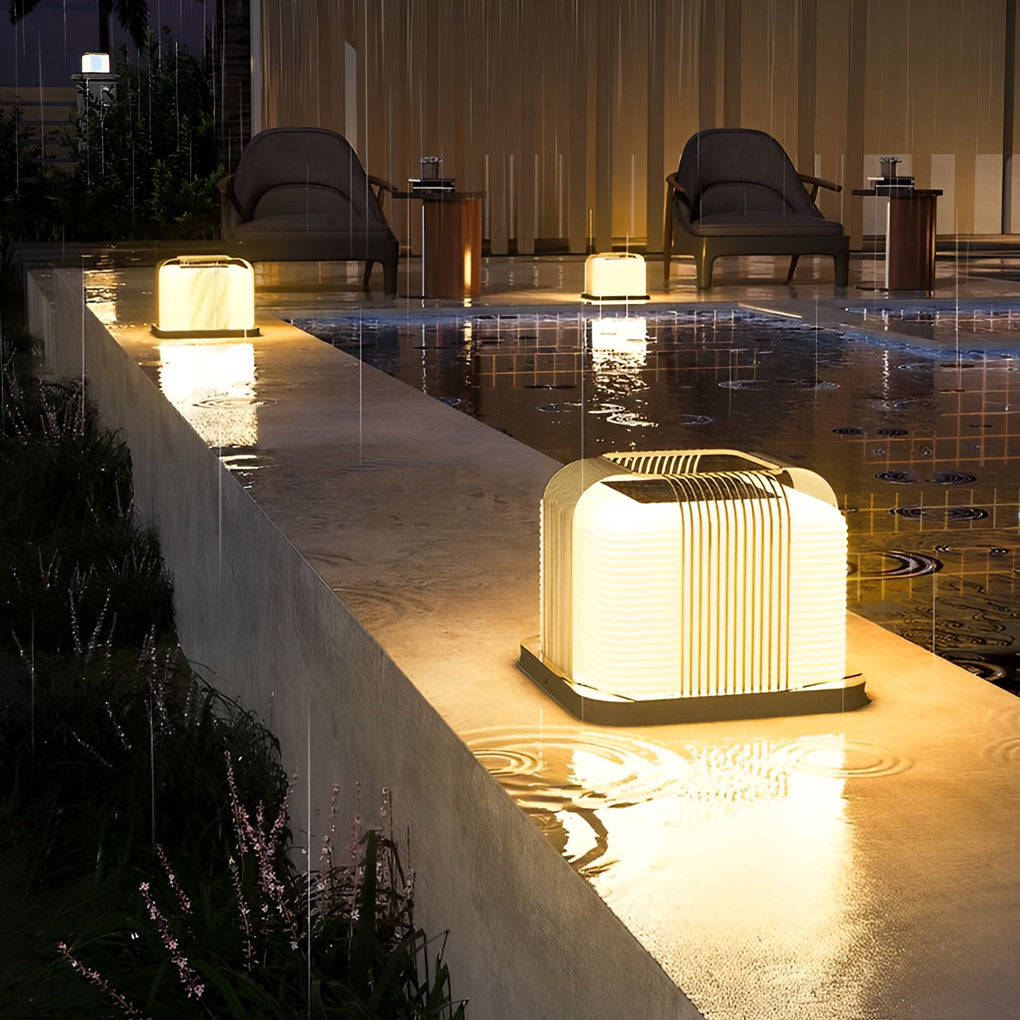 Contemporary outdoor pillar lights with a close-up of their glowing curved pattern.