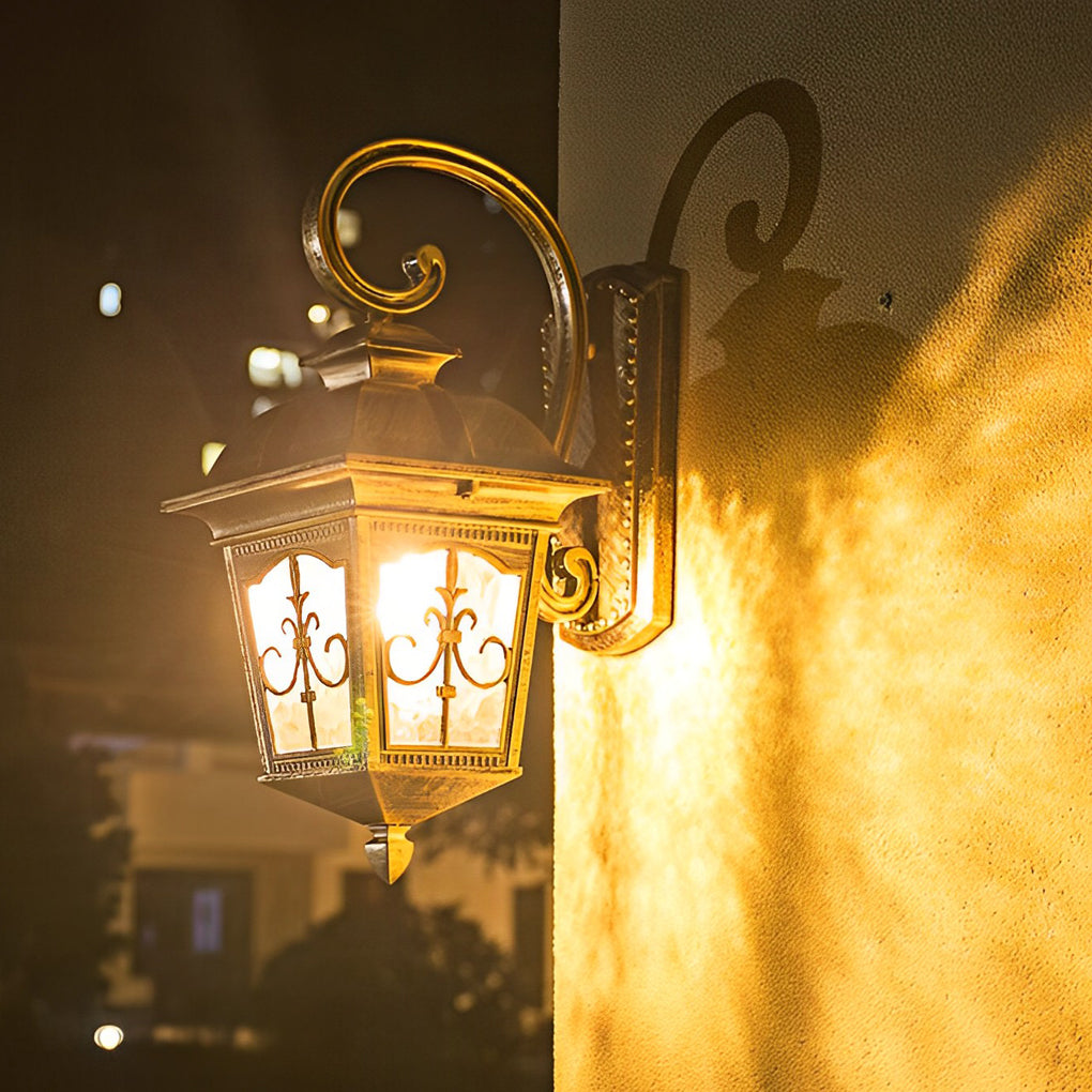 Contemporary outdoor wall light glowing at night with decorative metal detailing.