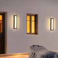 Contemporary outdoor wall lighting linear fixtures flanking modern hallway with warm illumination and yellow window glow