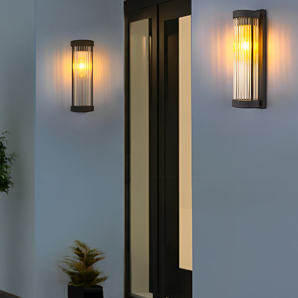 Pair of contemporary outdoor wall mount lights flanking a tall dark door on a smooth white stucco entryway.