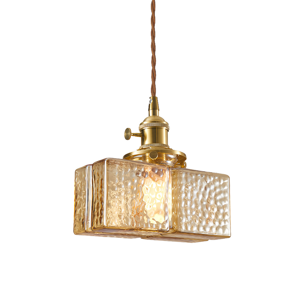 Contemporary square glass pendant light with fluted glass shade and brass accents for stylish interior lighting.