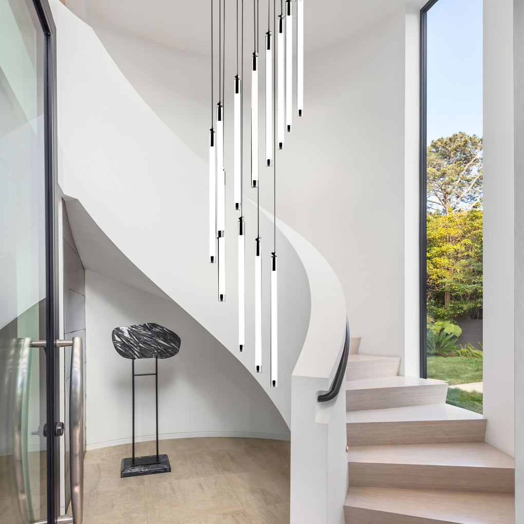 Contemporary staircase chandelier with pendant lights, illuminating a modern staircase with large windows.