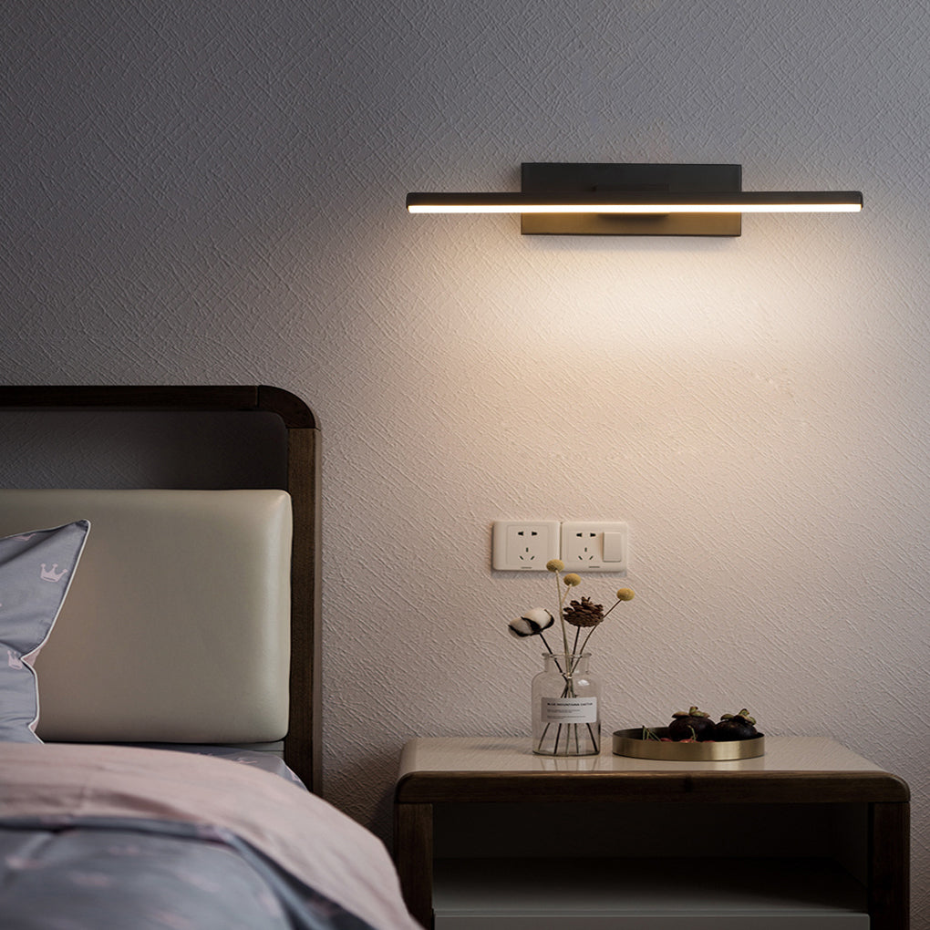 Contemporary swivel wall light with a black finish, illuminating a modern bedroom with a neutral-toned bed and pillows.