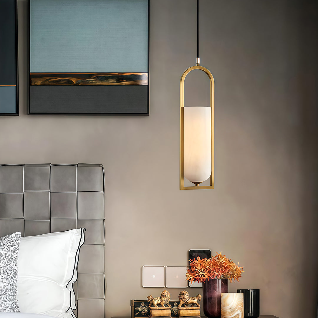 Copper hanging pendant lights illuminating modern kitchen space with clean lines and monochromatic palette