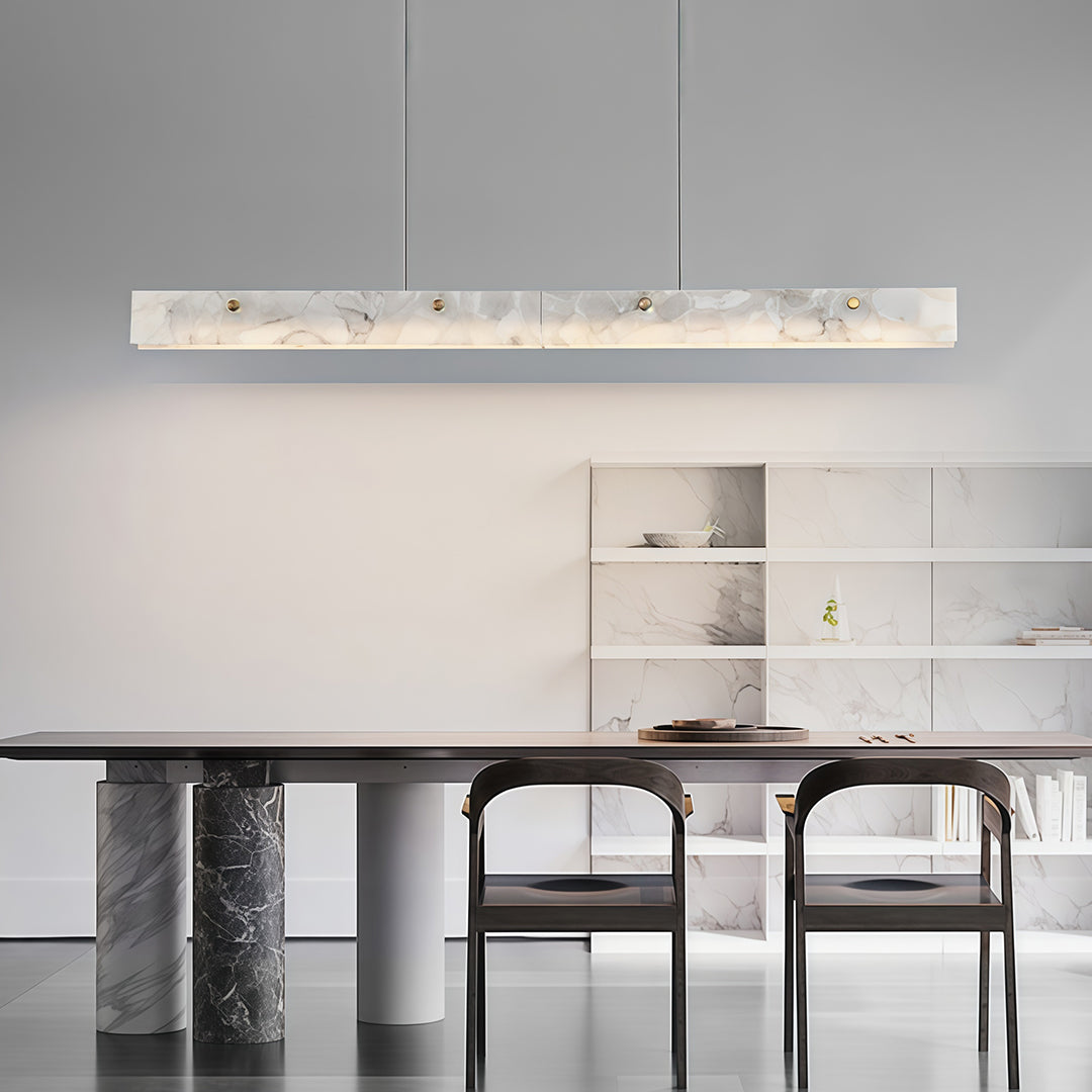 Copper metal pendant light hanging above a black dining table, creating a striking contrast in modern interiors.