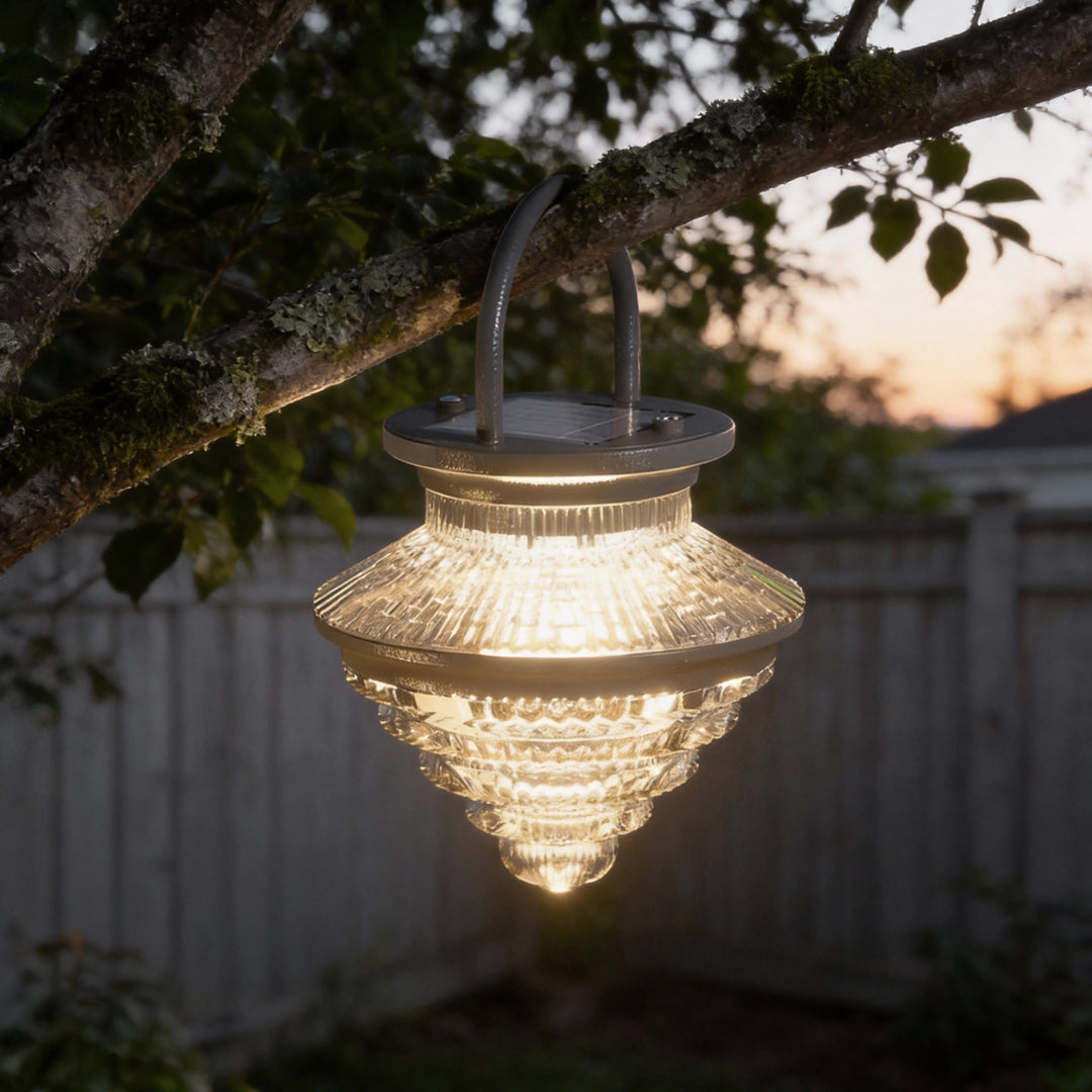 Single cordless acrylic hanging lantern suspended outdoors at dusk, providing soft illumination for backyard spaces.