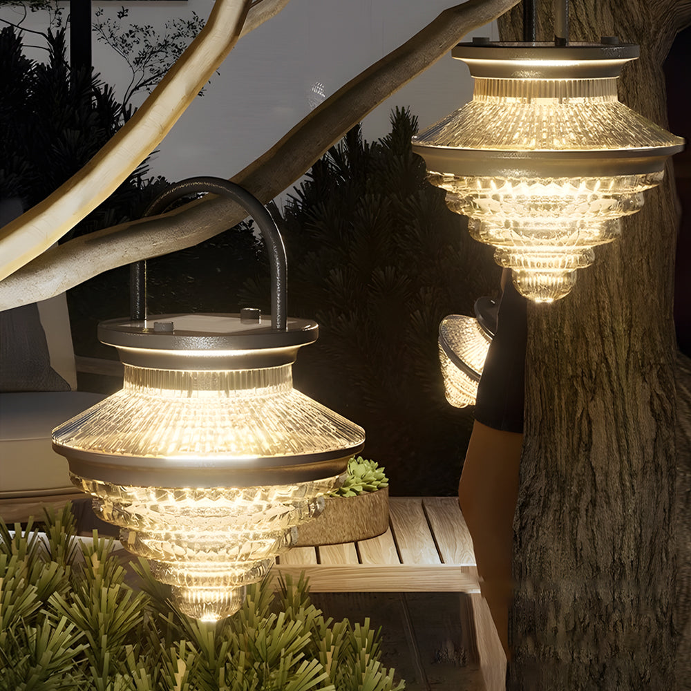Multiple cordless acrylic hanging lanterns displayed outdoors at night, enhancing garden ambiance with soft lighting.