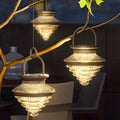 Cordless acrylic hanging lanterns glowing warmly from tree branches, creating a cozy and decorative outdoor setting.