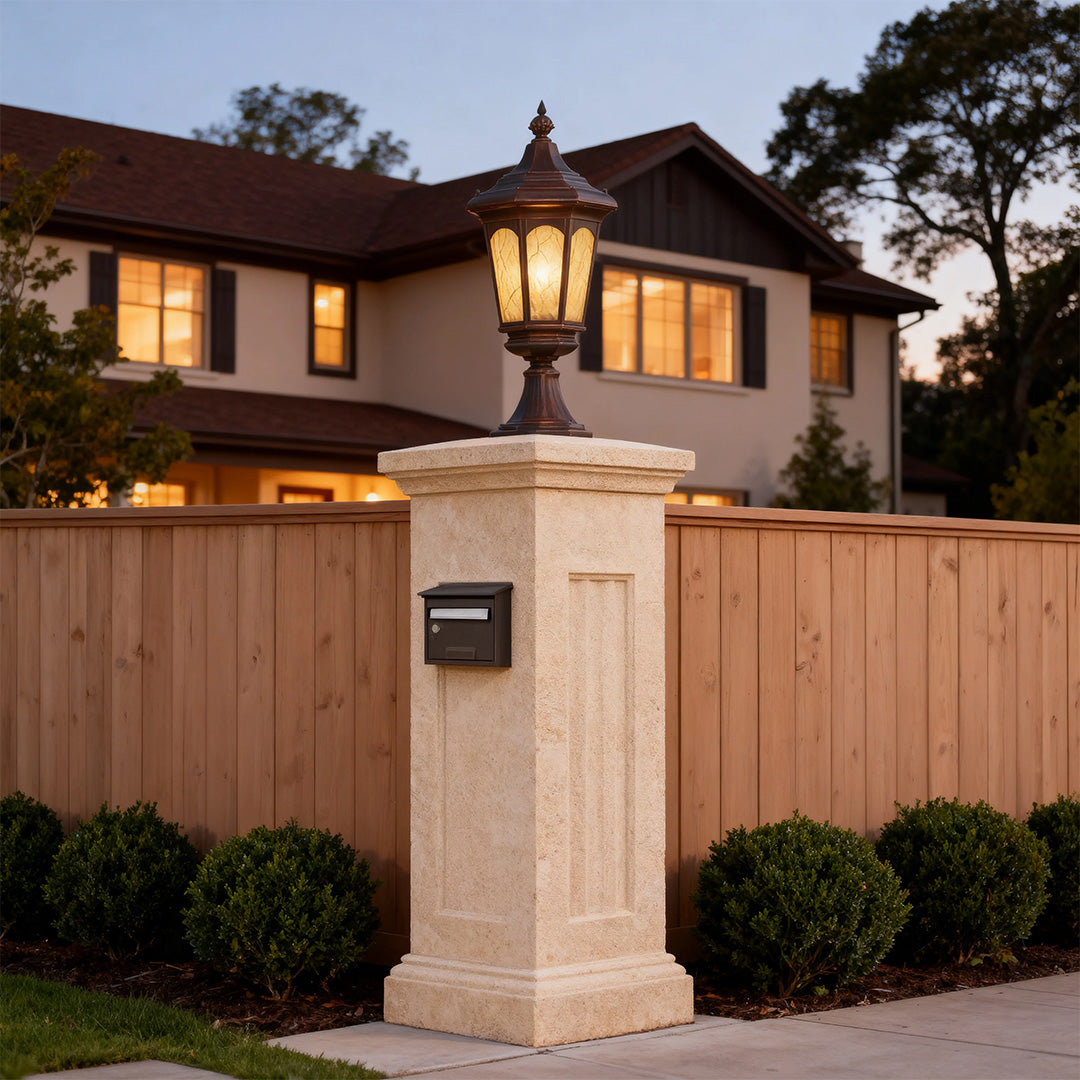 Craftsman residential pillar light brightening tan stucco column with wood fence and home lighting