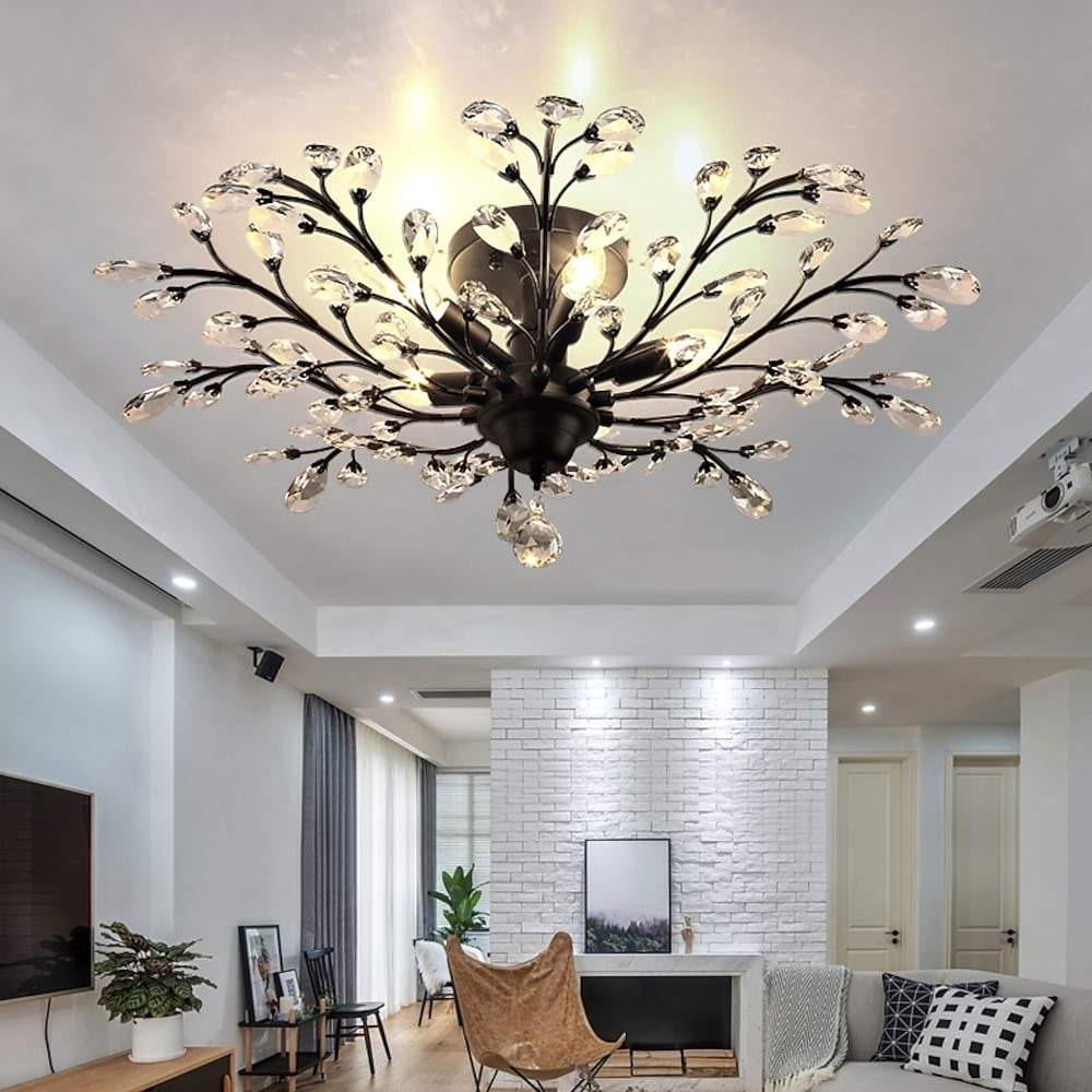 Crystal branch chandelier illuminating modern living room space.