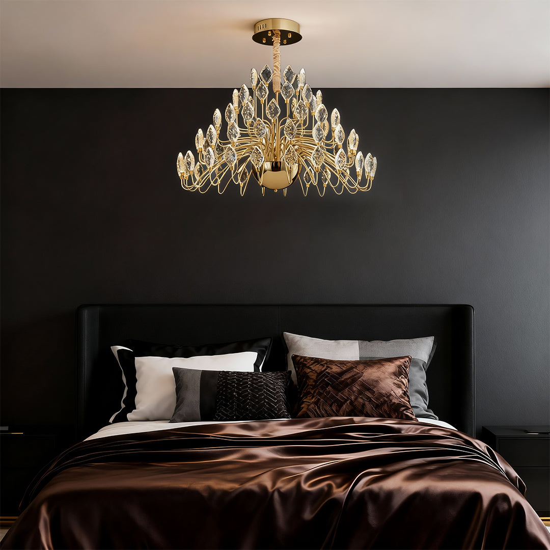 Crystal gold LED chandelier above a modern bedroom bed.