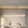 Crystal linear modern white pendant light illuminating a marble dining table in a contemporary dining room.