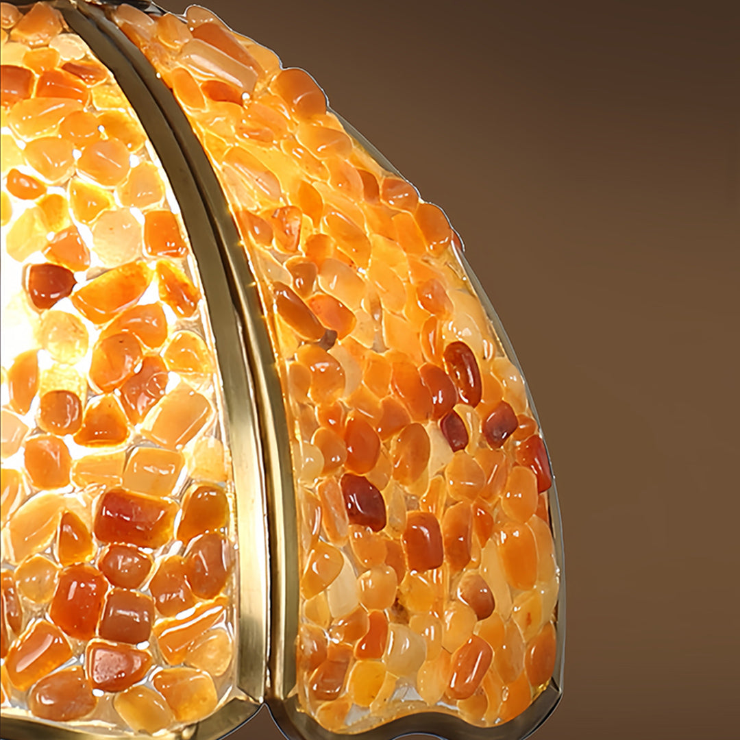 Close-up detail of small crystal pendant light showing amber glass texture and warm illumination